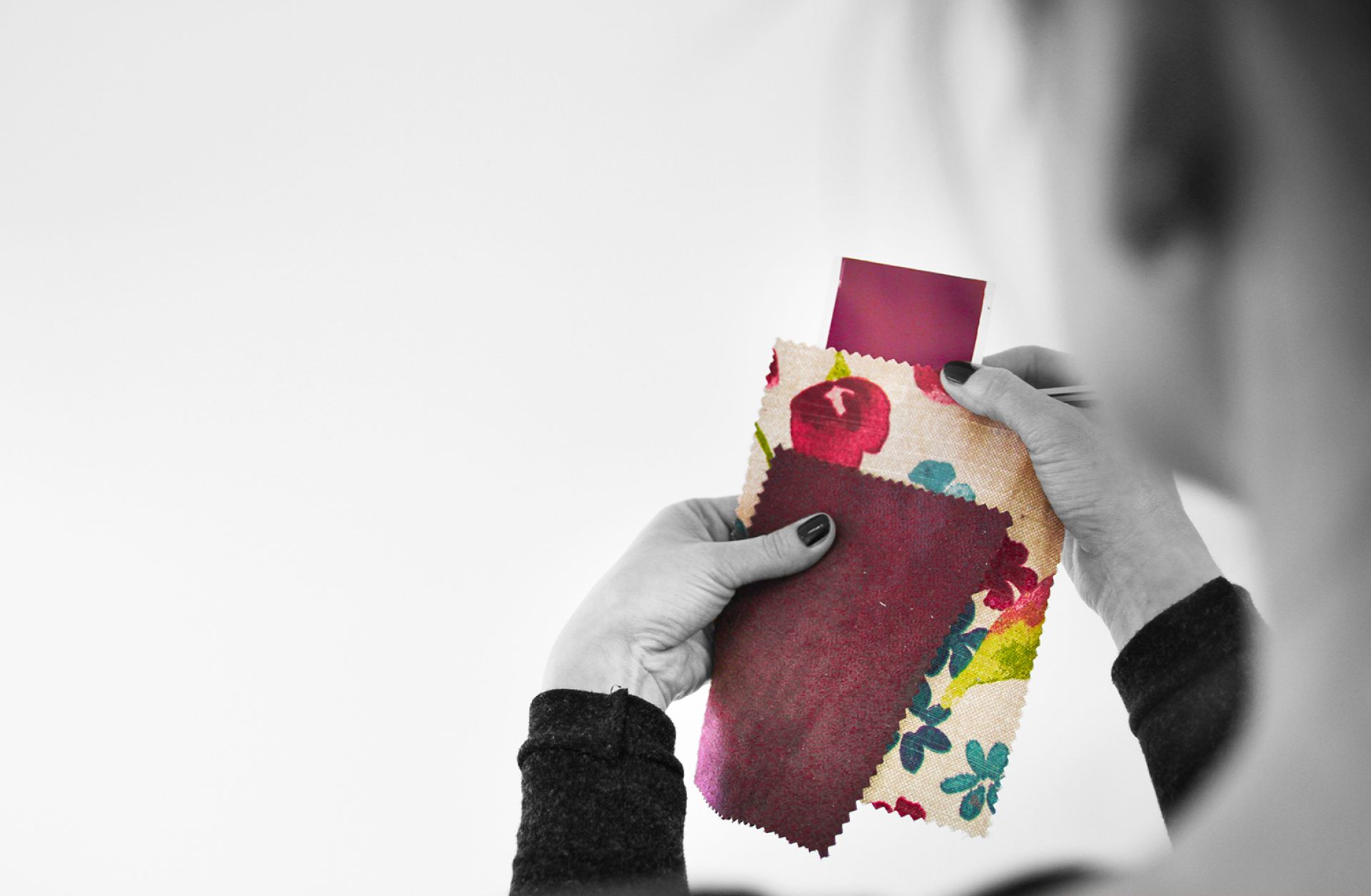 Woman comparing fabric sample to colour matched paint swatch